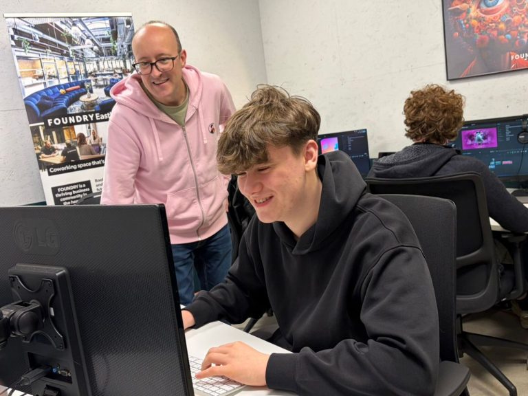 Work Experience Brian with a student, smiling and focused, at a computer in an office.